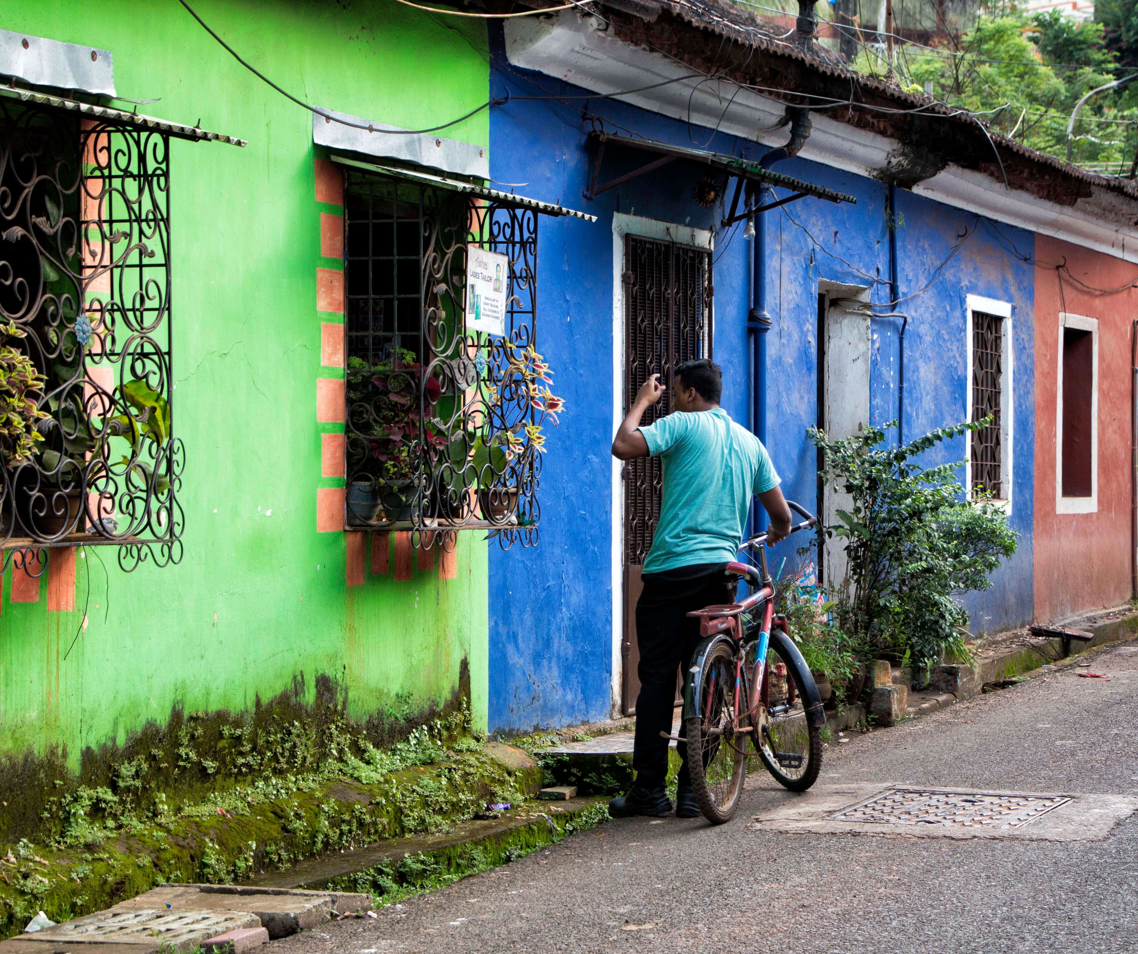 Man with bicycle outside shop in Panaji, Goa