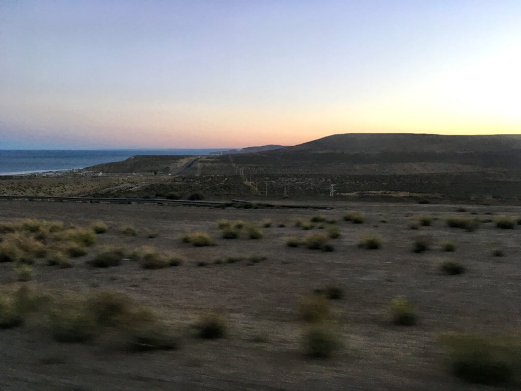 Sun setting over the Patagonian plains with the ocean in the background